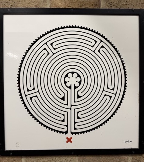Mark Wallinger labyrinth plaque 131 of 270, mounted on a brick station wall