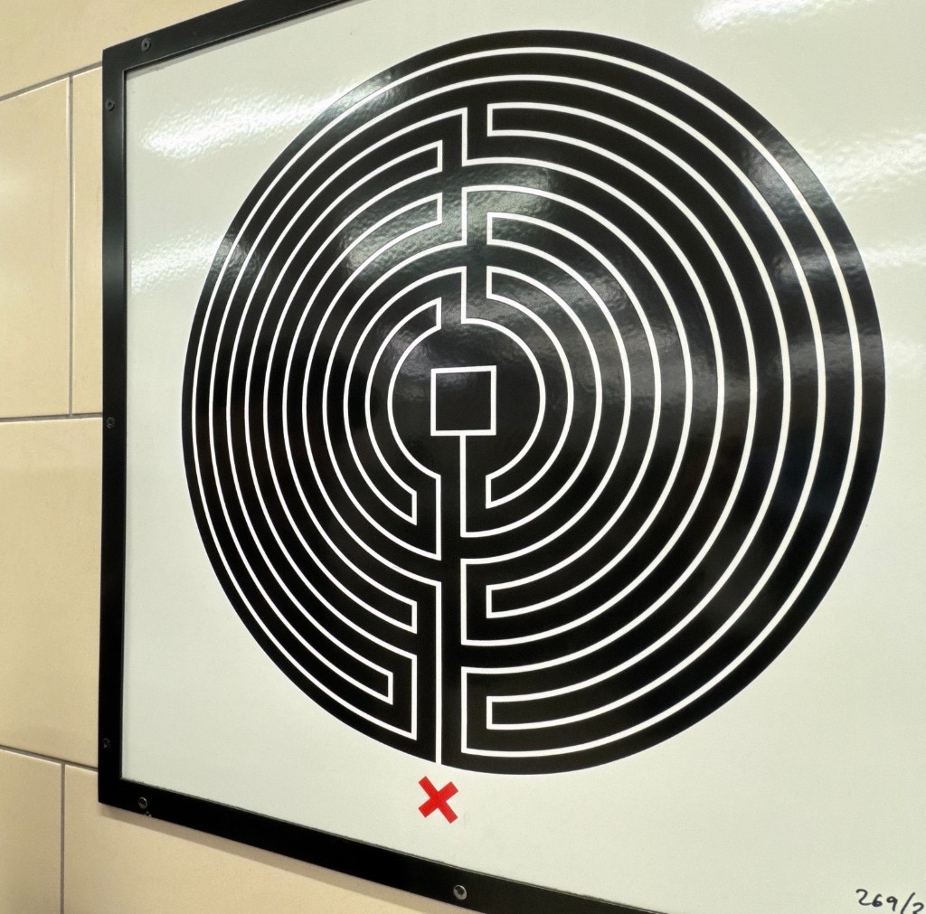 Mark Wallinger labyrinth plaque 269 of 270, mounted on a tiled station wall